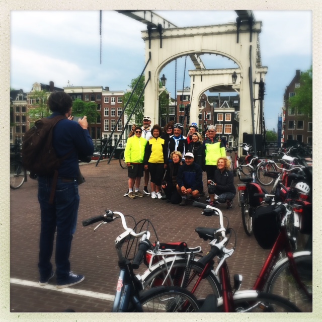 Eine Gruppe Radfahrer lässt sich auf einer Brücke fotografieren.